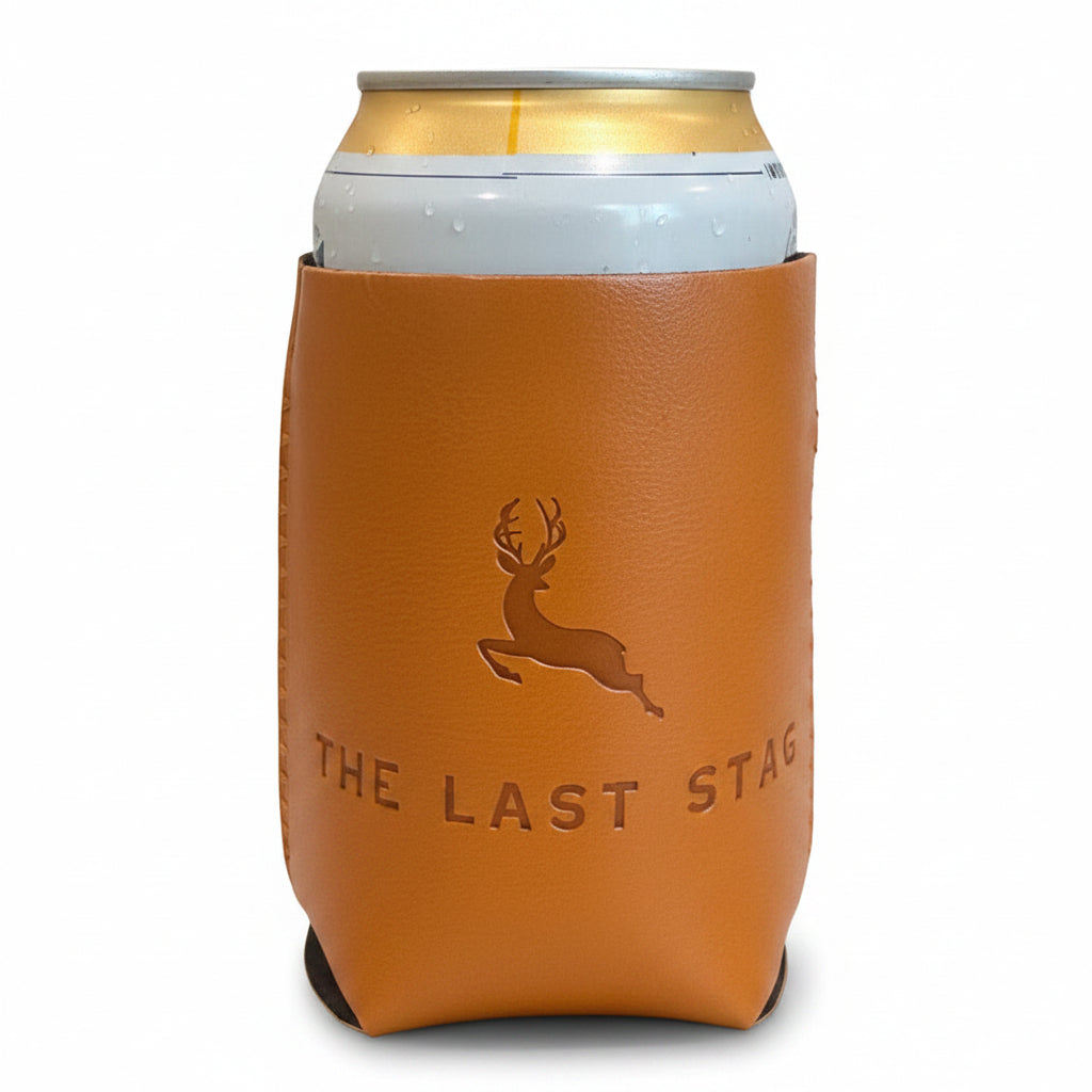 Brown leather can cooler with 'The Last Stag' branding on a wooden surface.
