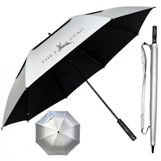 A golf umbrella shown open and closed, alongside the handle removed from the canopy. The canopy is UV-protective silver on the outside, with black ribs and a black underside, featuring the THE LAST STAG logo.